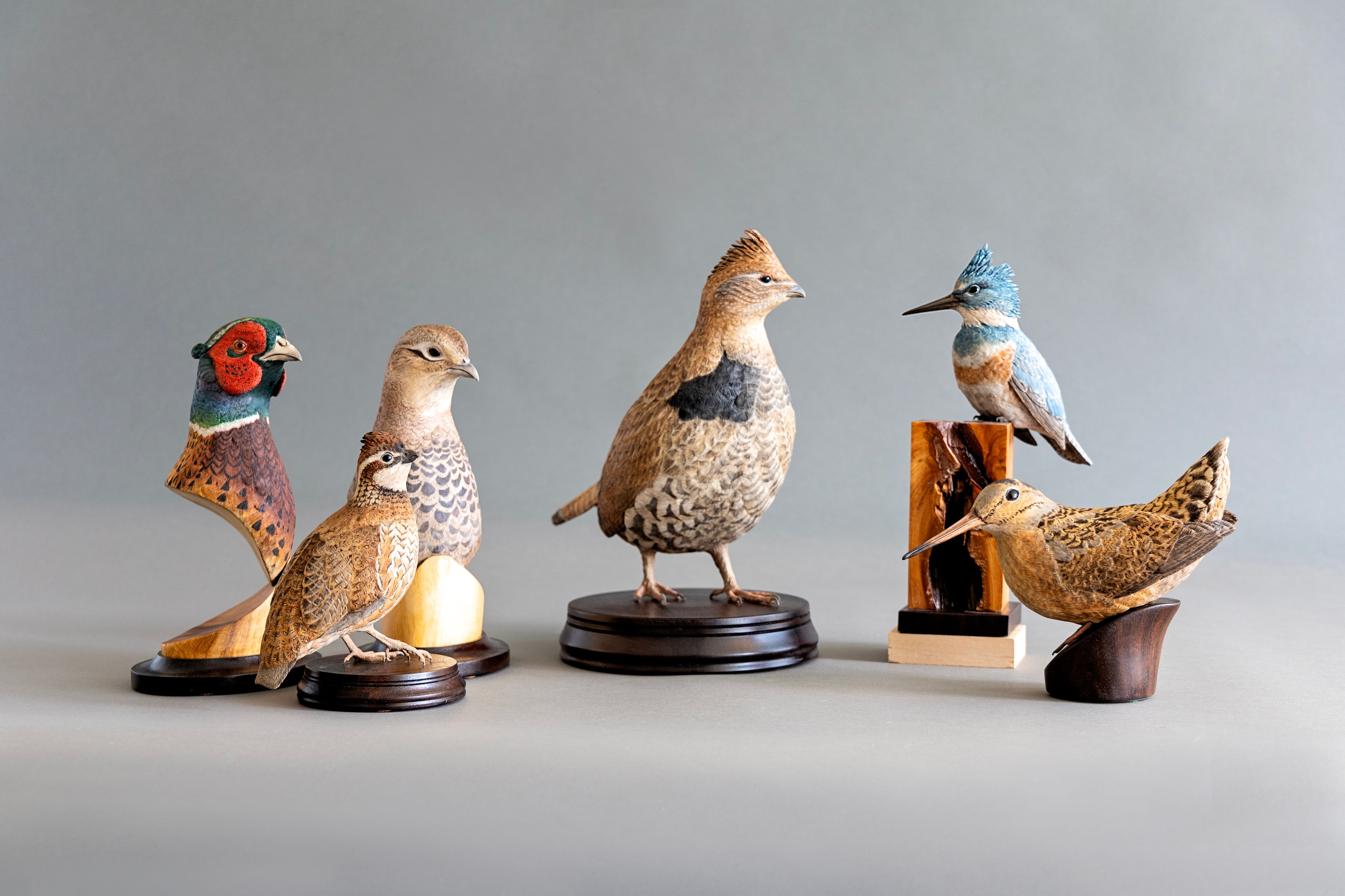 Collection of bird sculptures including pheasant, grouse, bobwhite quail, kingfisher, and woodcock